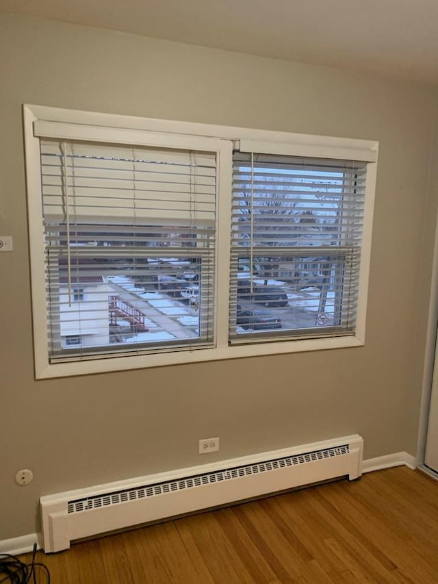 details with baseboard heating, wood finished floors, and baseboards