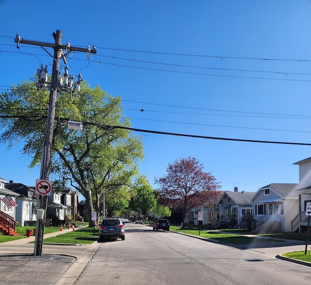 view of street with curbs, sidewalks, and a residential view