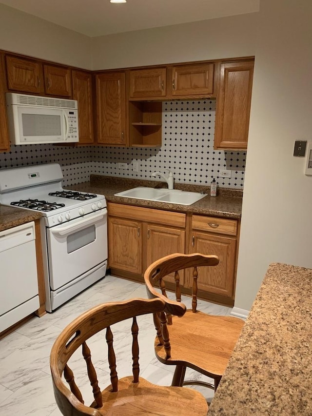 kitchen with white appliances, tasteful backsplash, marble finish floor, and a sink