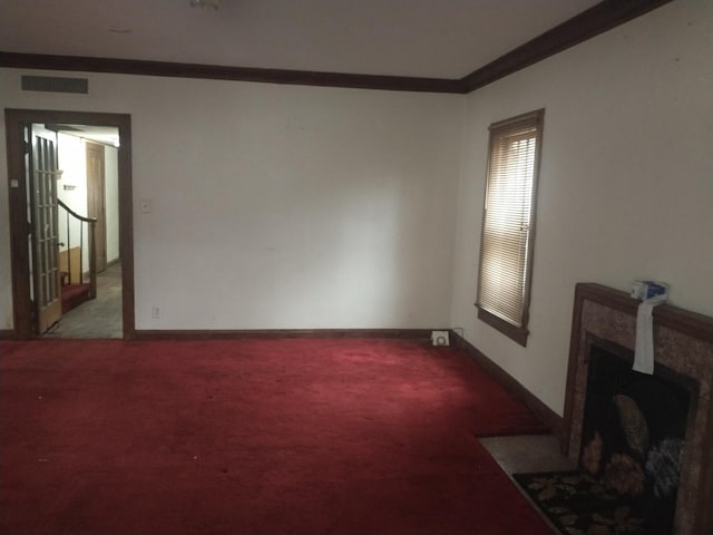 living room with carpet, crown molding, a fireplace, visible vents, and baseboards