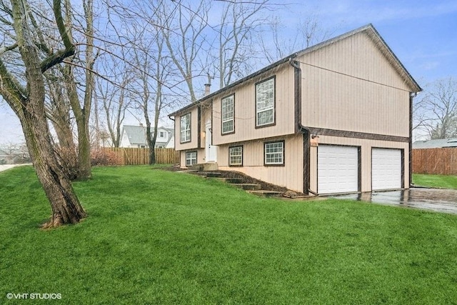 view of property exterior with driveway, a lawn, a chimney, and fence