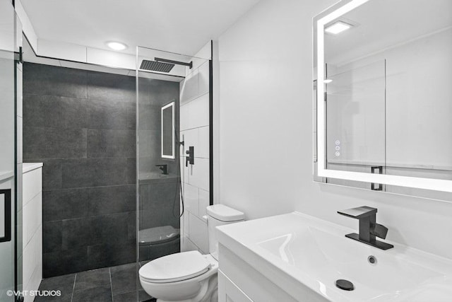 bathroom with toilet, tile patterned flooring, walk in shower, and vanity