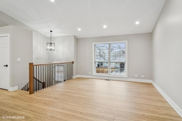 spare room featuring recessed lighting, baseboards, and wood finished floors