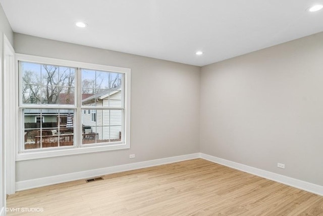 unfurnished room featuring recessed lighting, visible vents, light wood-style flooring, and baseboards