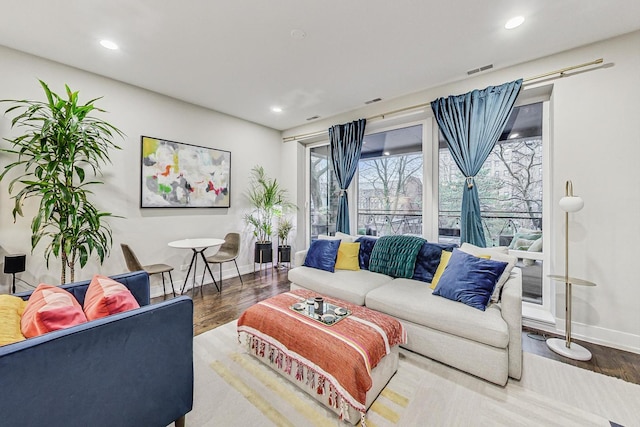 living area featuring recessed lighting, visible vents, baseboards, and wood finished floors