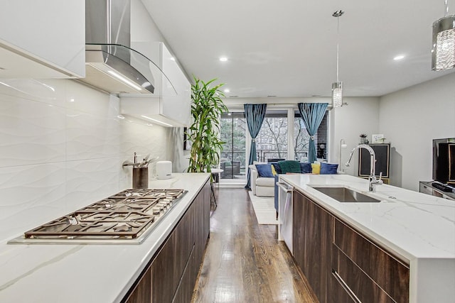 kitchen featuring modern cabinets, appliances with stainless steel finishes, a sink, and wood finished floors