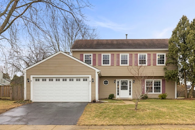 colonial-style house with a front yard, driveway, an attached garage, and fence