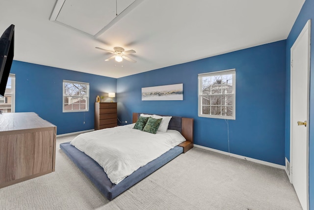 carpeted bedroom with attic access, multiple windows, ceiling fan, and baseboards