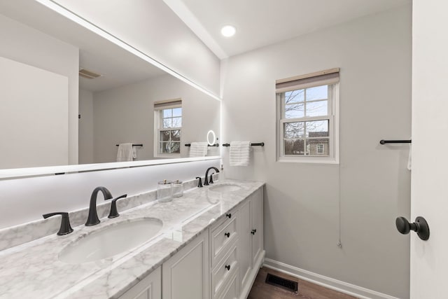 full bath featuring visible vents, a sink, and baseboards