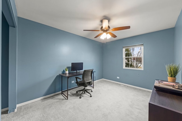 carpeted home office with a ceiling fan and baseboards