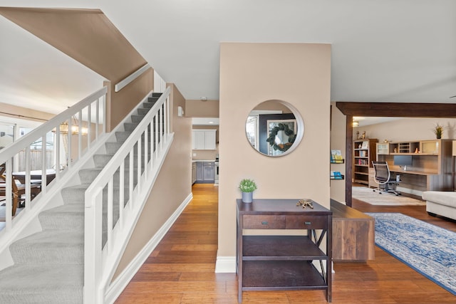 stairway with wood finished floors and baseboards