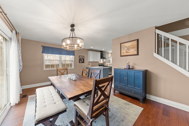 dining room featuring an inviting chandelier, wood finished floors, visible vents, and baseboards