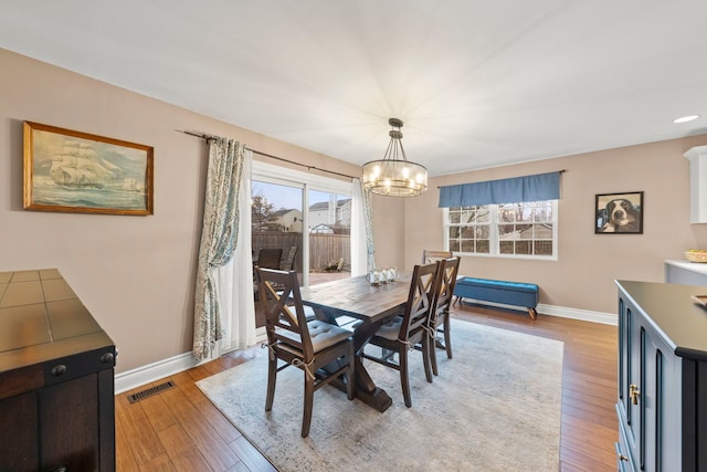 dining area featuring light wood-style floors, visible vents, and baseboards