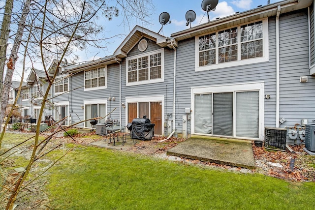 rear view of property with central AC unit, a patio, and a yard