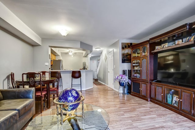 living room with baseboards and light wood-style floors