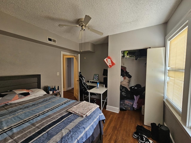 bedroom with multiple windows, a closet, wood finished floors, and visible vents