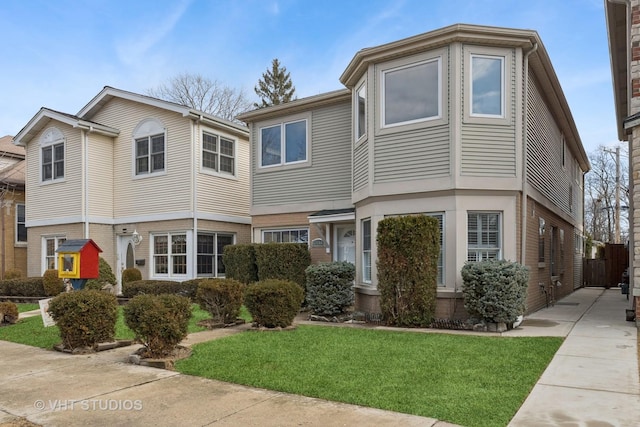 multi unit property featuring brick siding and a front yard