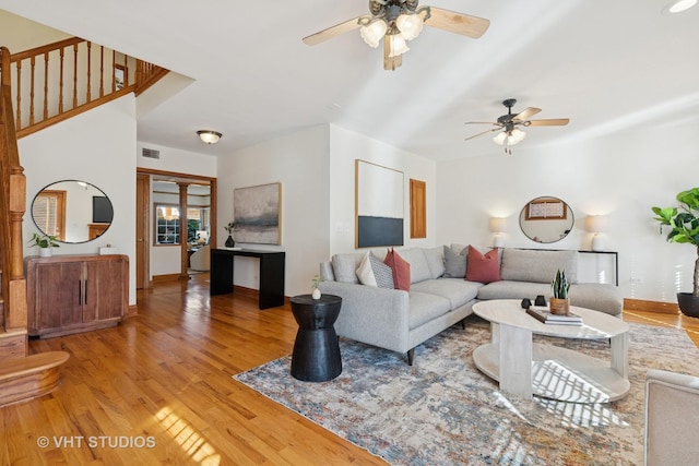 living room featuring visible vents, light wood-type flooring, and ceiling fan