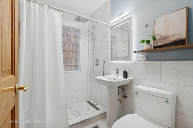 bathroom featuring tile walls, toilet, and a tile shower