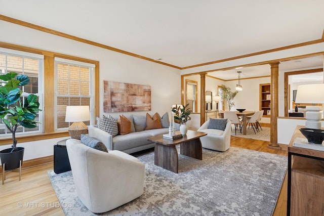 living room with ornamental molding, baseboards, ornate columns, and wood finished floors