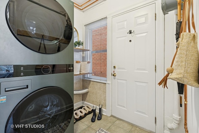 laundry area with light tile patterned floors, laundry area, and stacked washer / dryer