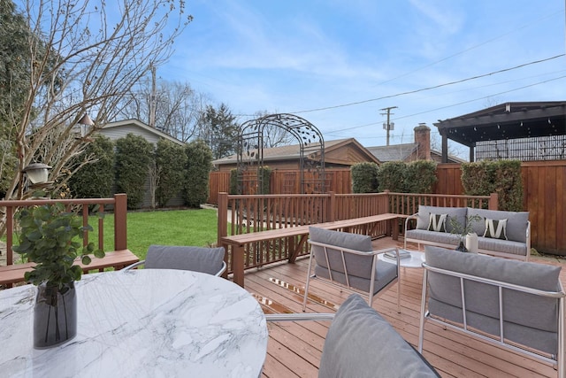 wooden deck featuring outdoor dining space, a yard, fence, and an outdoor hangout area