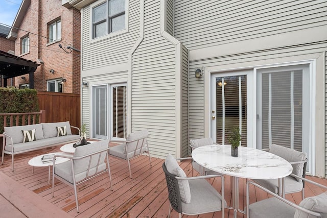 deck with an outdoor hangout area, outdoor dining area, and fence