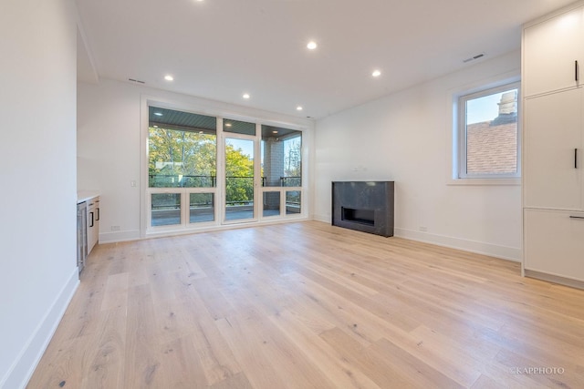 unfurnished living room featuring light wood-style floors, recessed lighting, visible vents, and a fireplace