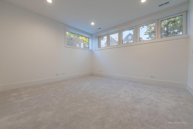 unfurnished room with baseboards, light colored carpet, visible vents, and recessed lighting