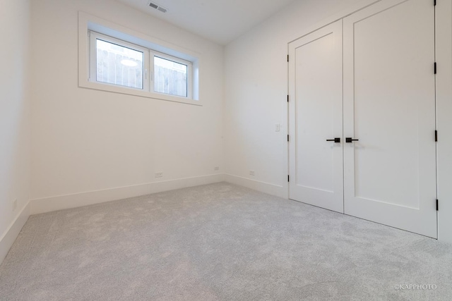 unfurnished bedroom featuring carpet floors, baseboards, visible vents, and a closet