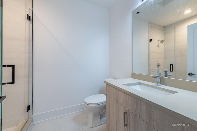 bathroom with a stall shower, vanity, toilet, and baseboards