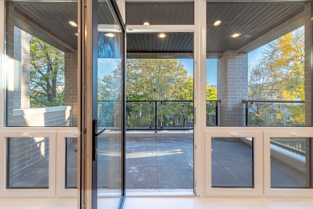 doorway with a wall of windows, a wealth of natural light, and recessed lighting