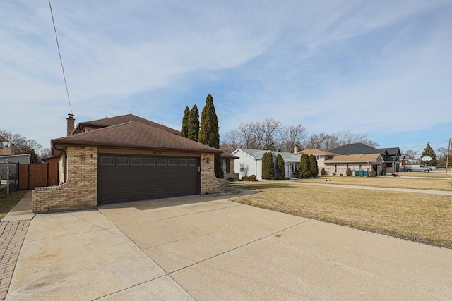 exterior space featuring a front yard, an attached garage, a chimney, concrete driveway, and brick siding