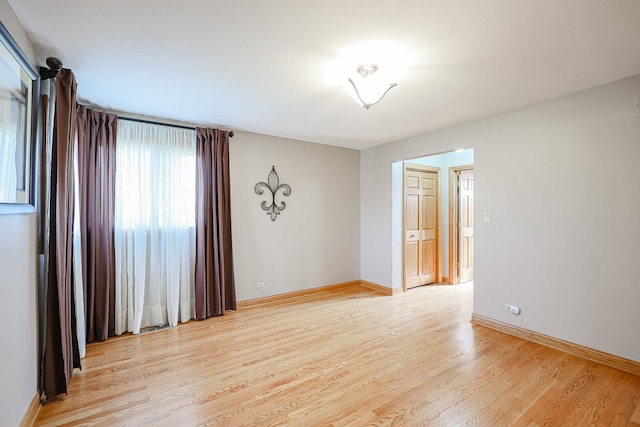 spare room with light wood finished floors and baseboards