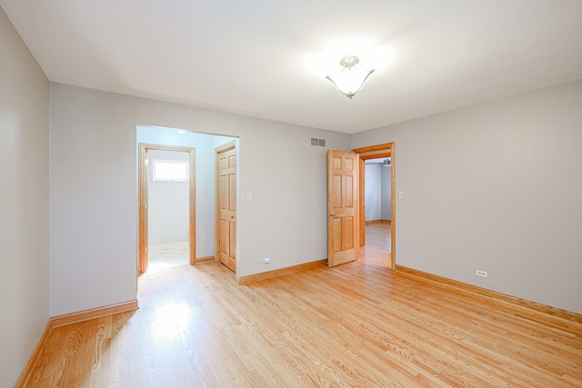 spare room featuring visible vents, baseboards, and light wood-style floors