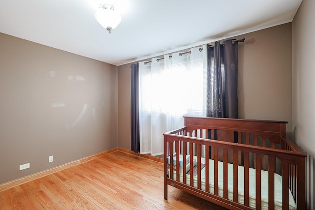 bedroom with baseboards and light wood finished floors