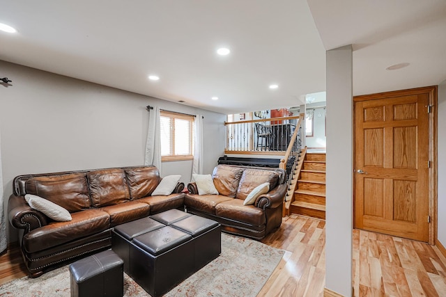 living area featuring stairs, recessed lighting, and light wood finished floors