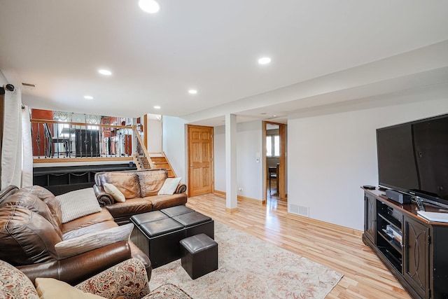 living room with recessed lighting, visible vents, stairs, and light wood finished floors