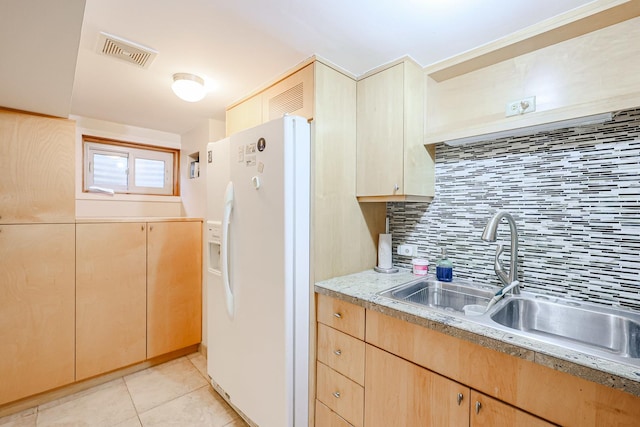 kitchen featuring visible vents, light brown cabinets, decorative backsplash, white fridge with ice dispenser, and a sink