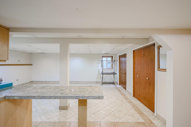 kitchen featuring light tile patterned flooring and a drop ceiling