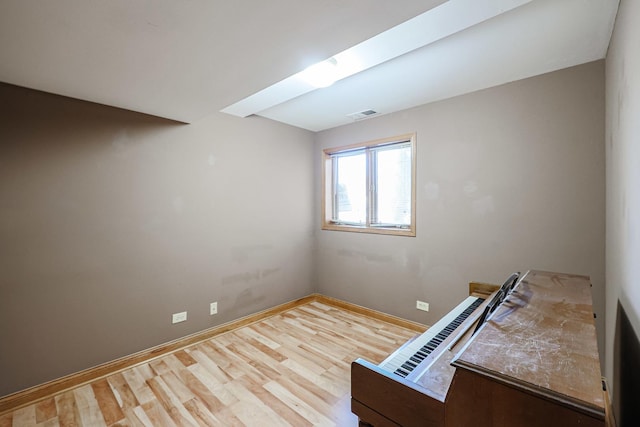 interior space featuring wood finished floors, visible vents, and baseboards