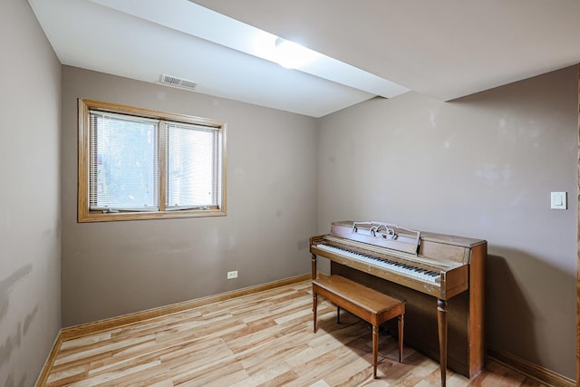 sitting room featuring light wood finished floors, visible vents, and baseboards