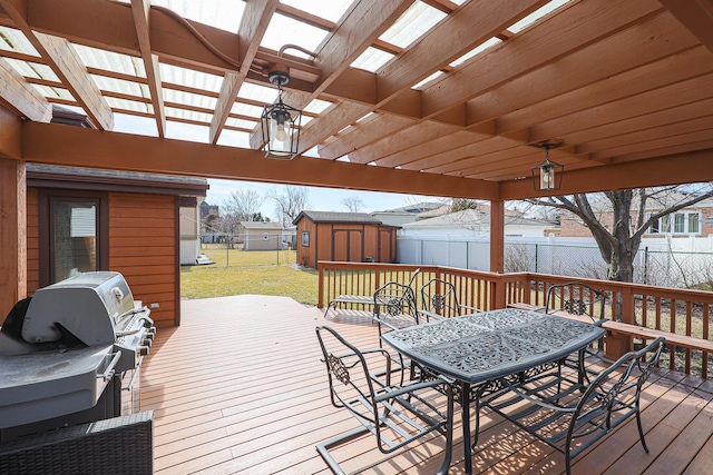 deck featuring outdoor dining space, a storage shed, an outdoor structure, and fence