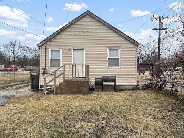 back of house featuring fence and a lawn