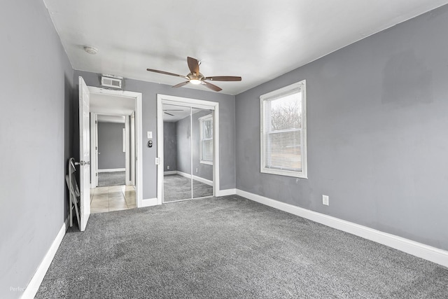 unfurnished bedroom featuring ceiling fan, visible vents, baseboards, a closet, and carpet