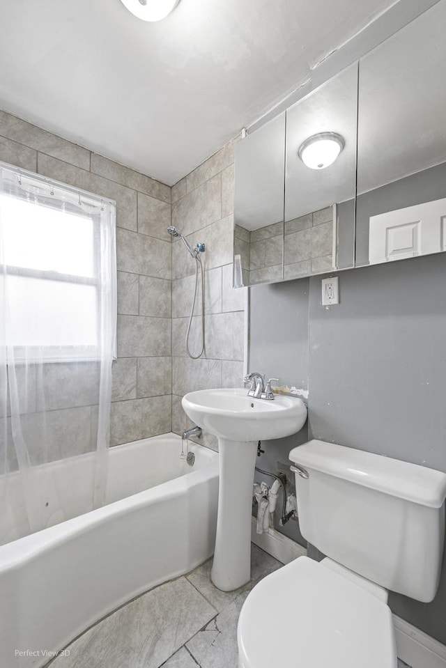 full bathroom featuring a sink, shower / tub combination, and toilet