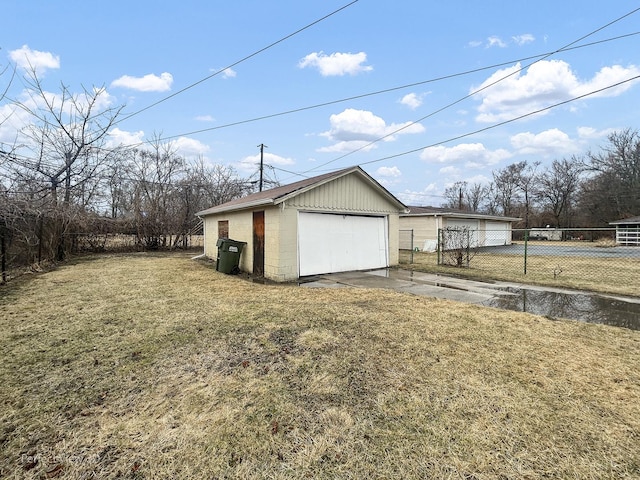 view of yard featuring an outbuilding, fence, and a detached garage