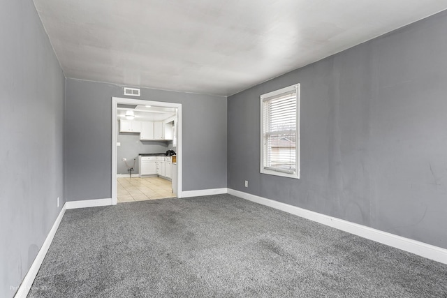 interior space with light carpet, baseboards, and visible vents