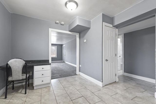 unfurnished office featuring light tile patterned flooring and baseboards