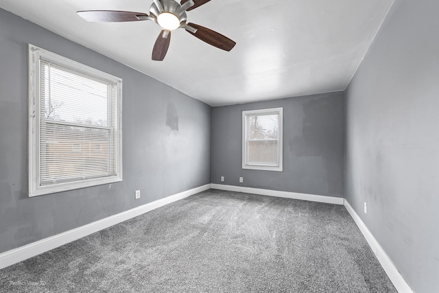 carpeted empty room with ceiling fan and baseboards